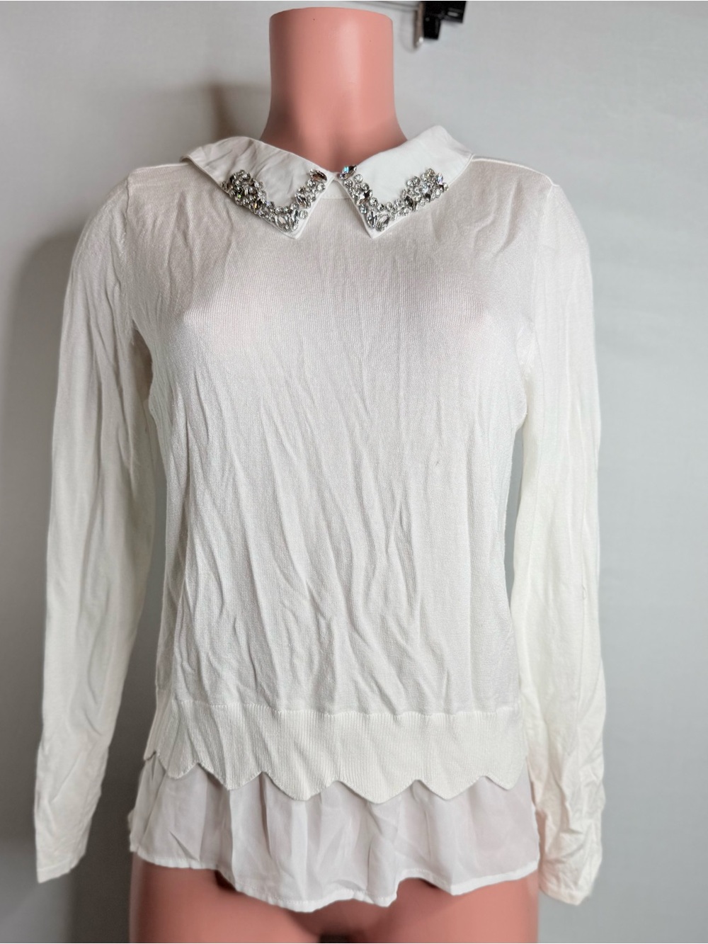 A white long-sleeved top featuring a white collar embellished with sparkling
